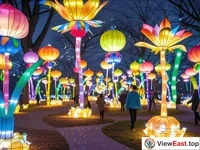 In the park at night, countless lanterns with unique shapes are shining with colorful lights. People are shuttling among the lanterns to admire them.