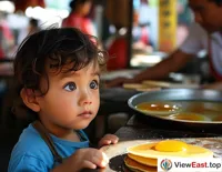 A child is curiously watching the master make the pancake roll, with anticipation in their eyes.