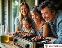 On a home balcony, a family is using a small electric grill to roast lamb skewers, enjoying the fun of a family barbecue.