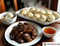 On a home breakfast table, a plate of liver stir-fry is accompanied by steaming buns as the family prepares to start a new day.