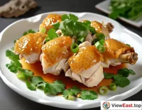 In the bustling atmosphere of a Cantonese morning tea, plates of White Cut Chicken accompany dim sum, as people savor the flavors while chatting, enjoying a leisurely morning.