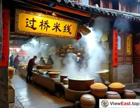 In a Yunnan ancient alley, a century-old shop displays a sign for Cross-Bridge Rice Noodles, with steam filling the air and customers savoring the authentic Yunnan flavor.