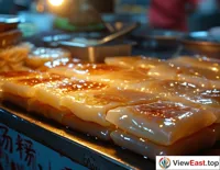 At a Guangdong night market, the light of a Cheong fun stall illuminates the night, with its smooth and richly filled Cheong fun making mouths water.