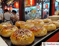 At a Shanghai tourist attraction, a long line forms in front of a soup dumpling shop, with tourists attracted by this unique delicacy and eager to try it.