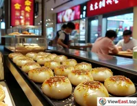 In a modern Shanghai mall, a trendy soup dumpling shop attracts many young people, who are curious about the modern presentation of this traditional snack.