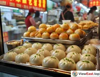 On a busy Shanghai street, a snack shop window is filled with freshly made soup dumplings, with office workers hastily buying them for breakfast.
