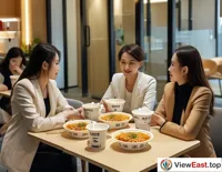 During lunch break in Guangxi offices, white-collar workers gather to share takeout Guilin rice noodles.