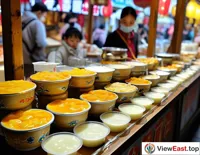 On a Qinghai snack street, a yogurt stall has a long line, with tourists eager to try this local delicacy.
