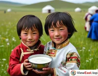 On Qinghai's grasslands, a herder's child holds a bowl of homemade yogurt, with a smile of satisfaction.
