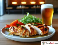 Roasted chicken breast in a modern minimalist restaurant, next to a cold beer, providing a relaxing dinner after a busy day.