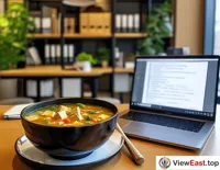 A bowl of tofu and vegetable soup in an office break room, next to a laptop, bringing a moment of relaxation to a busy workday.