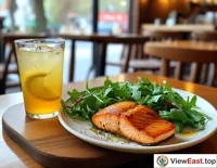 A plate of grilled salmon salad with a glass of iced lemon water in a quiet café, adding a touch of freshness to a leisurely afternoon.
