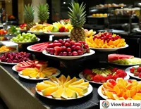Guests at a luxury hotel's buffet are drawn to the meticulously decorated fruit platters, each bite a temptation for the taste buds.
